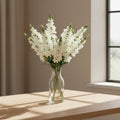 Vase en verre transparent avec fausses plantes et tiges de mufliers blancs pour le salon